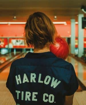 Image illustrant une femme tenant une balle de bowling dans un espace de divertissement, commercial Eurocap.